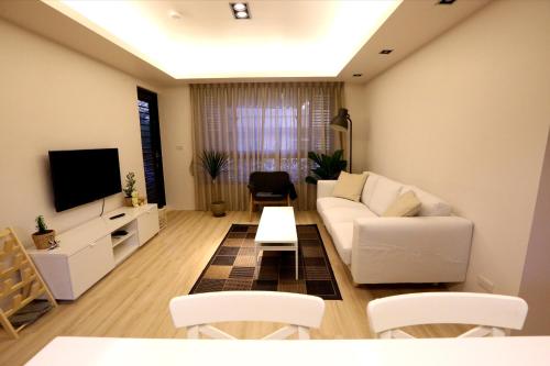 台北Lienmei 月租房的客厅配有白色沙发和电视