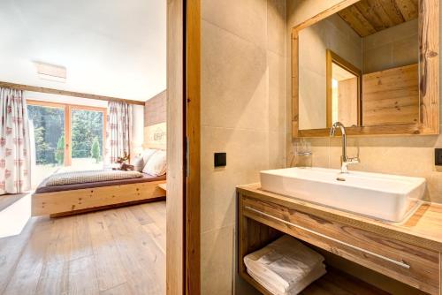 比尔塞贝格Rufana Lodge的一间带水槽的浴室和一张位于客房内的床