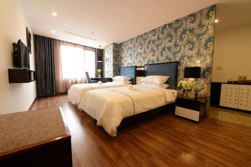 河内河内碧海Spa酒店的一间大卧室,配有两张床和壁画