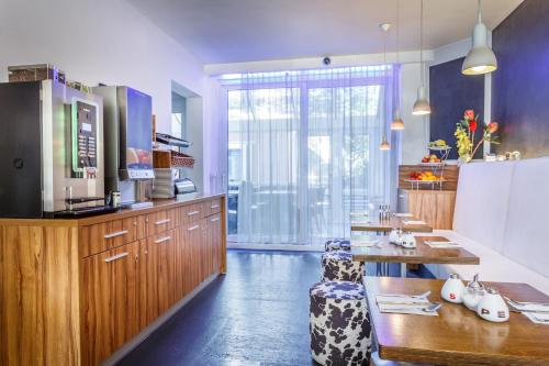 阿姆斯特丹维多利亚酒店的厨房配有木制橱柜、桌子和柜台。
