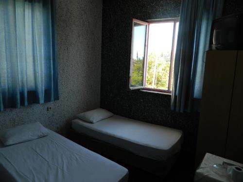 安塔利亚Sunrise Hotel的小房间设有两张床和窗户