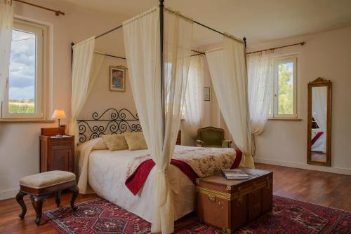 Agugliano兰迪格格拉那罗酒店的一间卧室配有一张带天蓬的大床