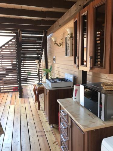 古达乌塔Guest House na Vozba 9A的铺有木地板,设有带炉灶的厨房。