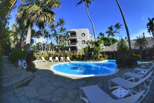 喀巴里特埃尔玛格尼菲科公寓式酒店的度假村的游泳池,带椅子和大楼