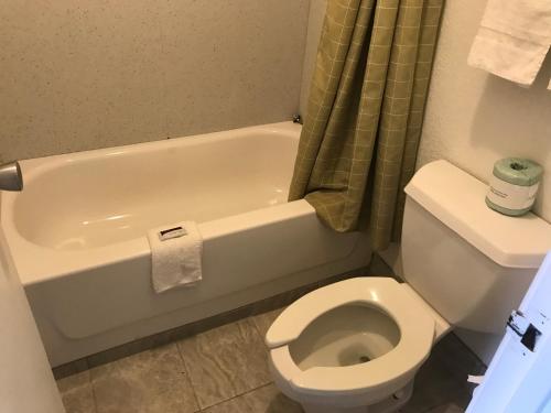 夏洛特Royal Inn的浴室配有白色卫生间和浴缸。