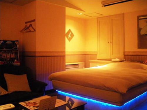 深谷绿山酒店的一间卧室配有一张蓝色的灯光床