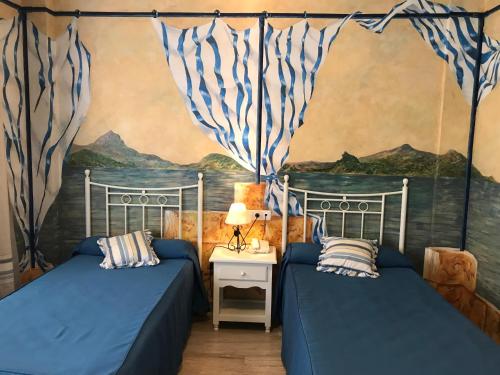 普里埃格·德·科尔多巴拉斯罗萨斯酒店的一间卧室设有两张床,墙上挂着一幅画