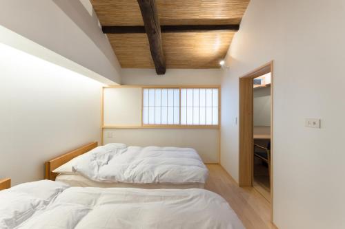 京都奔腾公寓 的一间卧室设有两张床和窗户。