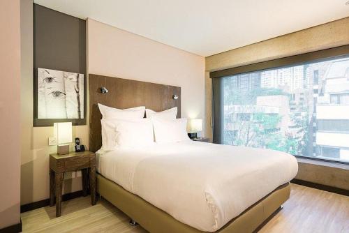 波哥大Hotel CityFlats的一间卧室设有一张大床和大窗户