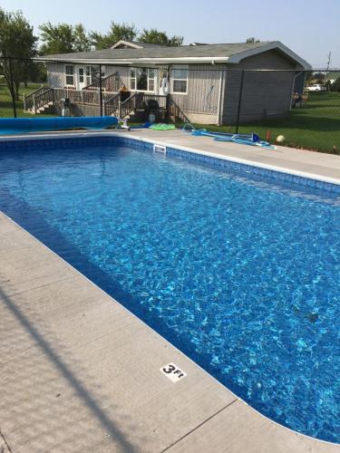 Rustico梦想编织者小屋和居家度假屋酒店的一座大蓝色游泳池,位于房子前