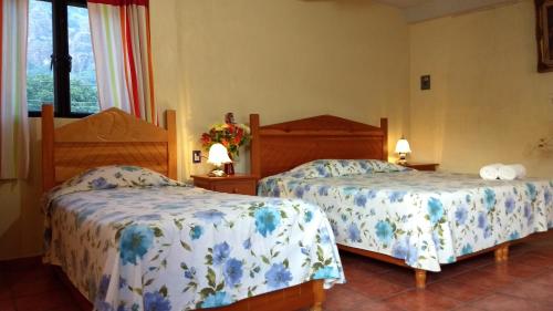 迪坡斯特兰Posada Cuallicochi的一间卧室设有两张床和窗户。