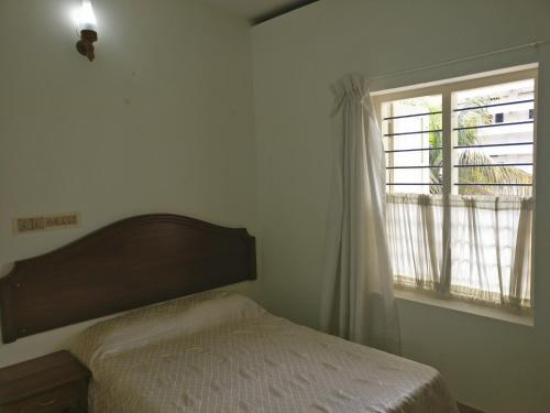特里凡得琅Safire Residency的一间卧室设有一张床和一个窗口