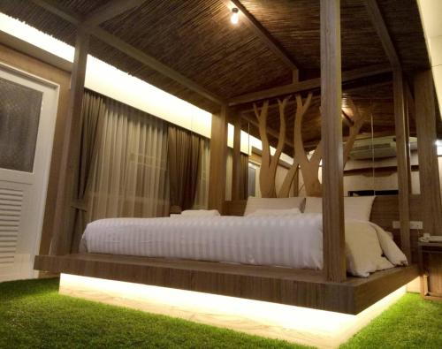 班达拉朗西纳瓦大酒店的一间卧室配有一张带白色床单的大床
