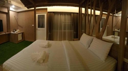 班达拉朗西纳瓦大酒店的卧室配有带毛巾的大型白色床