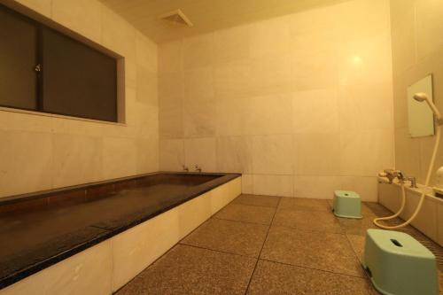 汤泽町瓦拉碧索山林小屋的一间带水槽的浴室和墙上的电视