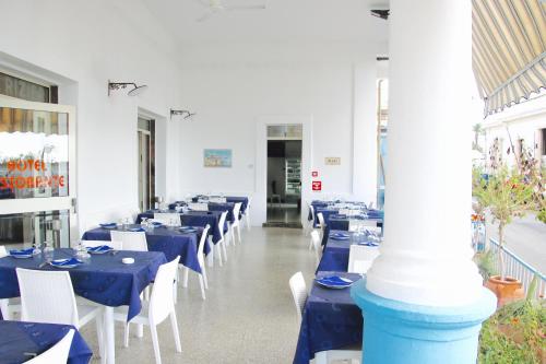 莱乌卡Hotel Rizieri的用餐室配有蓝色桌子和白色椅子