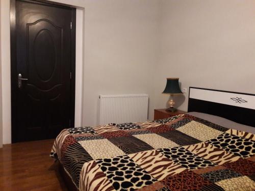 西格纳吉Goga Guesthouse的一间卧室设有一张床和一个黑色的门