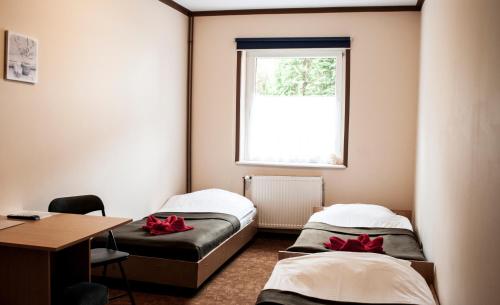 托伦银色高速公路旅馆的客房设有三张床、一张书桌和一个窗户。