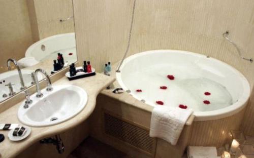 罗萨里奥罗斯大厦酒店的浴室配有浴缸和红色的盥洗盆。