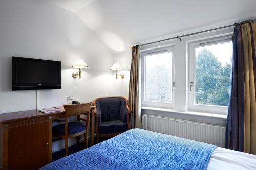 根措夫特金塔夫特酒店的配有一张床、一张书桌和一扇窗户的酒店客房