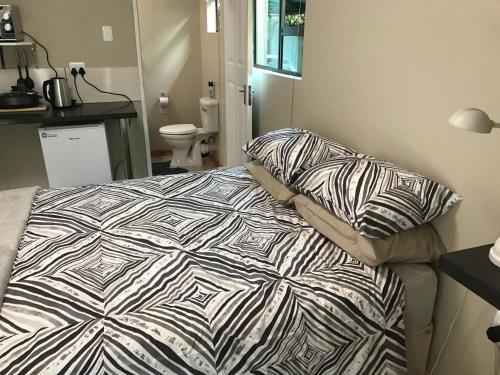 布隆方丹B@home的一间卧室配有一张带被子和枕头的床