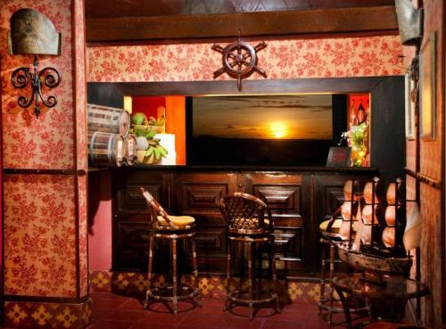 考卡亚Barbanera Club & Hotel de Charme的一间酒吧,里面设有凳子和电视