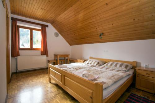 索尔察瓦Turistična kmetija Perk的一间卧室设有一张带木制天花板的大床