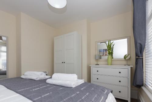 费勒姆Prince Apartments的一间卧室配有一张床、梳妆台和镜子