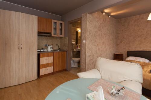 布达佩斯安瓦宾馆的一间带白色沙发的客厅和一间厨房