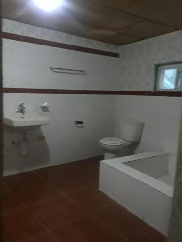 海地角Pablo Guess House的浴室配有卫生间、盥洗盆和浴缸。
