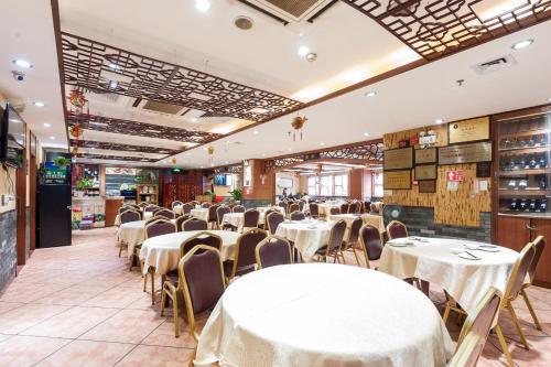 广州康柏斯酒店的一间设有白色桌椅的用餐室