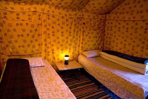列城Mulkila Adventure Camp的一间卧室配有两张床和一张带台灯的桌子