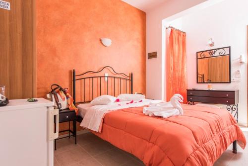 佩里萨沃拉别墅酒店的一间卧室配有一张橙色墙壁的床