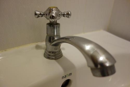 曼谷微笑酒店的浴室水槽配有银色水龙头