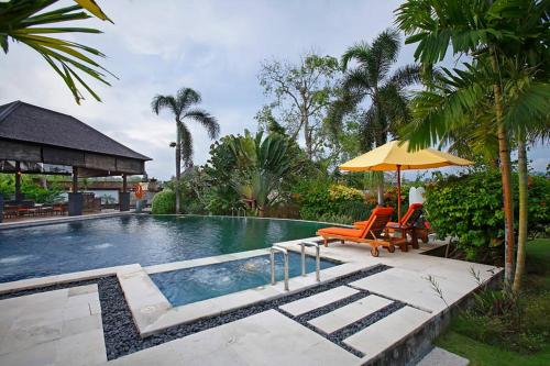 克拉玛斯巴厘岛橙色别墅的一个带两把椅子和遮阳伞的游泳池