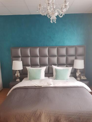 索林根霍尔舍酒店的一间卧室设有一张蓝色墙壁的大床