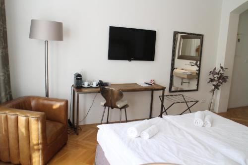 布拉格荣格曼酒店的一间卧室配有一张床、一把椅子和镜子