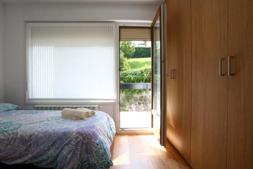 宏达瑞比亚Higer Bidea 1 - Basquenjoy的一间卧室设有一张床和一个滑动玻璃门