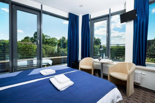 考纳斯考纳斯城市酒店的酒店客房设有蓝色的床和阳台。