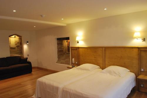 圣让萨韦讷Hôtel Restaurant Kleiber的卧室配有一张白色的大床和一张沙发。
