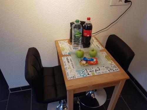 弗里茨拉尔Appartement Stein的桌子上放着两瓶苏打水和苹果