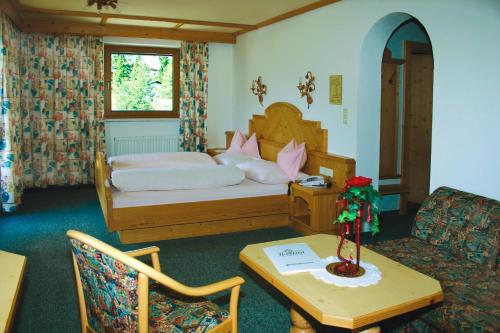 洛伊塔施高地酒店的酒店客房,配有床、桌子和桌子。