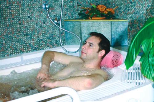 洛伊塔施高地酒店的躺在浴缸里的男人