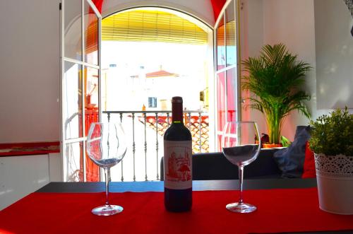 马拉加Dream Apto Old Town的桌子上放有一瓶葡萄酒和两杯酒