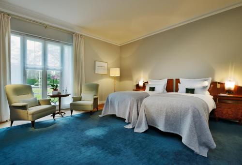 汉堡雅各布路易斯酒店的一间卧室配有两张床和两把椅子