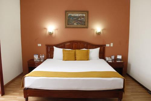 比亚埃尔莫萨马丹比亚埃尔莫萨贝斯特韦斯特酒店的一间卧室配有一张带黄色枕头的大床