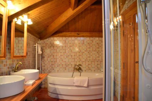 Herrera de ValdecañasVilla Ferrera Posada Rural的浴室配有两个盥洗盆和浴缸。
