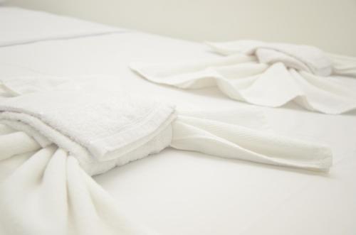 帕林廷斯Hotel Icamiabas的床上铺着白色的毯子