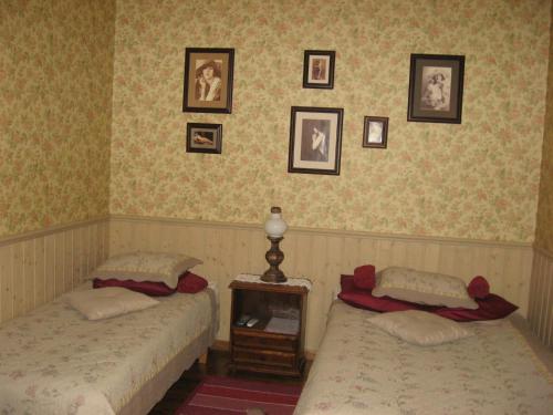 TreimaniKalbuse House的卧室内的两张床,墙上挂有照片