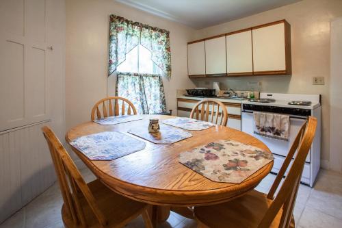Margaretville乡村套房酒店的厨房配有木桌和椅子